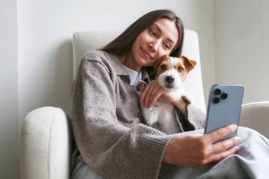Genç bir kadın köpeğiyle selfie çekiyor. Boşluğu kopyala, arkaplan.