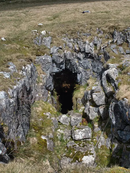 An ancient cave entrance set amongst the hills of Littondale in the Yorkshire Dales
