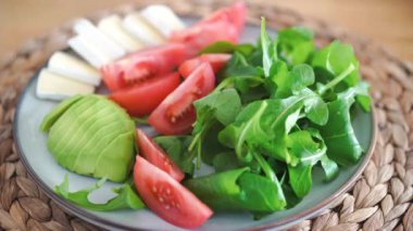 Siyah tuzlu tuz, roka ile tabak, domates ve avokado, camembert veya brie peyniri. Yüksek kalite 4k görüntü
