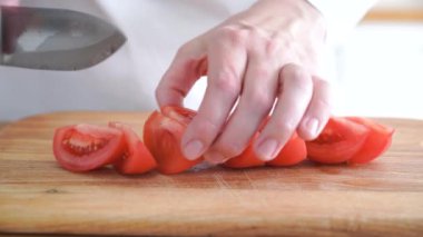 Tahta kesme tahtasıyla domates kesen kadın. Sağlıklı yemek hazırlıyorum. Yüksek kalite 4k görüntü