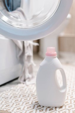 Çamaşır deterjanı ve çamaşır makinesinin yakınındaki kumaş yumuşatıcısı. Çamaşır makinesinde peshtemal havlu. Yüksek kalite fotoğraf