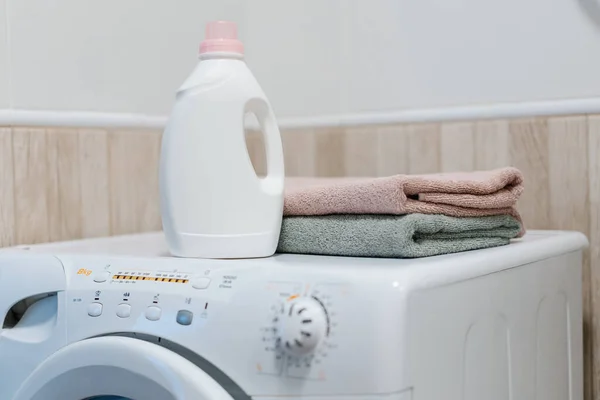 stock image Washing gel liquid laundry detergent and fabric softener on washing machine, clean towels on washing machine. High quality photo