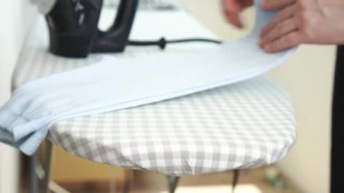 Ütü masasında ütülenmiş çocuk tozluklarını katlayan kadın. Ev işleri işte. Rutin ev işleri. Yüksek kalite 4k görüntü