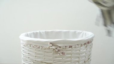 Kadın eli çamaşır sepetini açar, peştemal havluyu çamaşır sepetine koyar ve kapatır. Yüksek kalite 4k görüntü