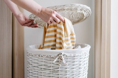 Kadın eli uzun kollu tişörtü çamaşır sepetine koydu. Yüksek kalite fotoğraf