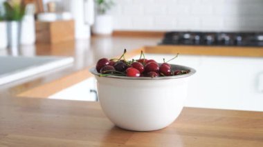 Çocuk elleri, tahta masadan kirazlarla kase alır. Yüksek kalite 4k görüntü