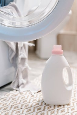 Çamaşır deterjanı ve çamaşır makinesinin yakınındaki kumaş yumuşatıcısı. Çamaşır makinesinde peshtemal havlu. Yüksek kalite fotoğraf