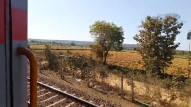 Yüksek hızlı Hint treni tren istasyonundan geçiyor. Trenden içeriye bakıyor.