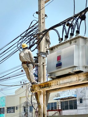 Yüksek Voltaj Transformatörünün Yakınındaki Tanınmayan Elektrikçinin Düşük Açı Görünümü