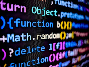 Closeup of computer software code on a digital screen with colorful characters displayed in dark mode on a black background