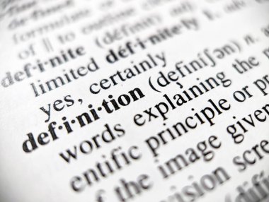Dictionary definition word defined on a paper page with focus blur