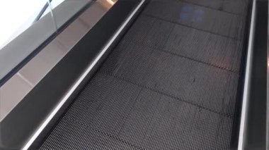 Binanın içinde düz zemini ve düz yürüyen merdiveni olan elektrikli bir yürüyen merdiven..