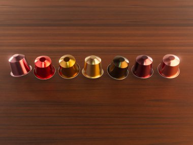 İzole edilmiş ahşap zemin üzerinde yüzen renkli kahve kapsüllerinin yakın çekim görüntüsü - 3 boyutlu canlandırma