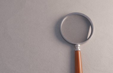 Beyaz kağıt yüzeyinde ahşap saplı normal bir büyüteç.