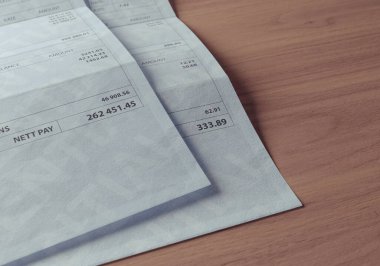 İki sahte maaş çekini gösteren bir konsept ve net ödemede büyük bir fark var. Gelir eşitsizliğini vurguluyor.