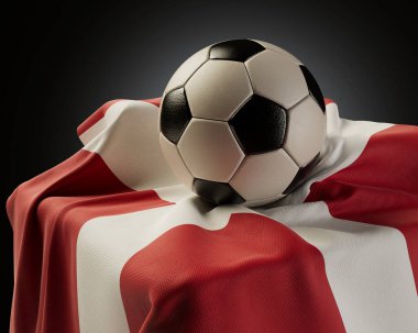 Sıradan bir futbol topu, izole edilmiş bir stüdyo arka planında bir kaideye sarılı bir Danimarka bayrağı üzerinde dinleniyor.