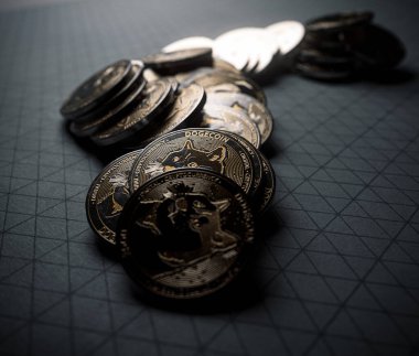 A fallen stack of gold physical dogecoin coins on line paper on a dark background - 3D render