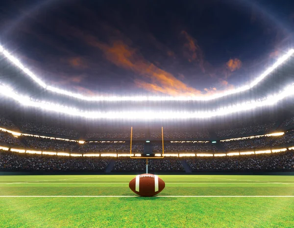 An American football on the centre line in a stadium with posts on a marked green grass pitch at night under illuminated floodlights - 3D render