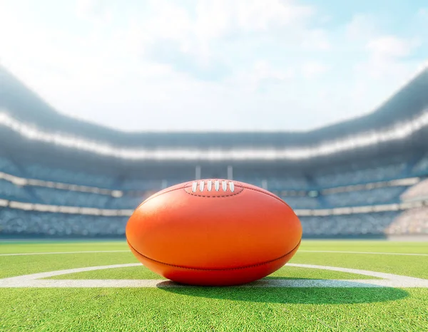 スタジアムの中央線にある赤いオージーのルールボールで 日中は緑色の芝生のピッチに投稿されます — ストック写真