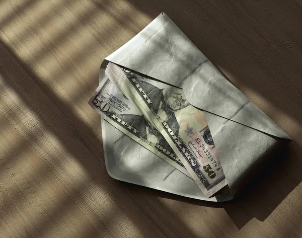 在喜怒无常的灯光下 在木制表面的信封里堆放着一堆堆美元钞票 3D渲染 — 图库照片