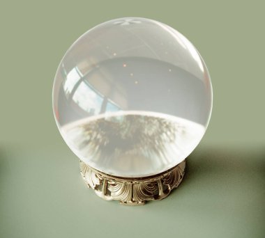 Süslü süslemeli, beyaz stüdyo arka planında pirinç tabanlı bir falcı kristal küresi.