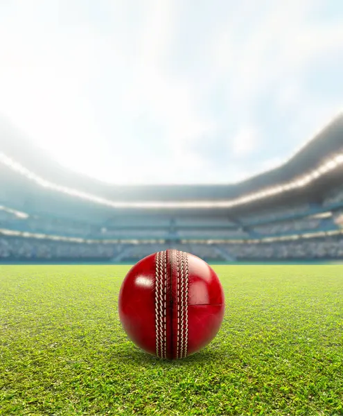 stock image A generic seated cricket stadium showing a red cricket ball on a green grass surface in the day time under a blue cloudy sky - 3D render