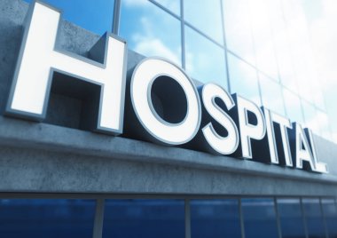 Gündüz vakti maruz bırakılan beton ve yansıtıcı camlardan yapılmış modern jenerik hastane binasının girişinin üzerinde genel tabela.