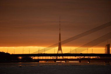 Letonya 'nın başkenti Riga' da donmuş Daugava nehri ile güzel bir kış gündoğumu manzarası. Kuzey Avrupa 'nın renkli şehir manzarası.