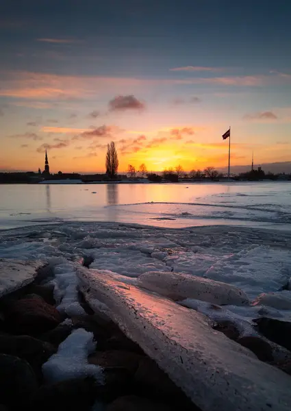 A beautiful winter sunrise landscape in Latvia capital Riga with frozen river Daugava. Colorful cityscape of Northern Europe.