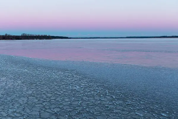 A beautiful minimalist landscape of frozen lake with a horizon in the distance. Winter scenery of Northern Europe.