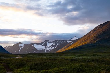 İsveç 'teki Sarek Ulusal Parkı üzerinde dramatik bir akşam havası var. Kuzey Avrupa 'nın yaz manzarası..