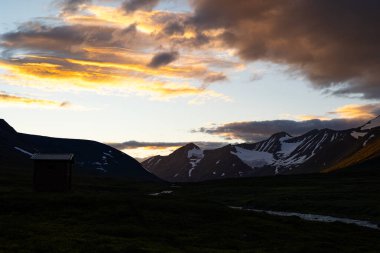 İsveç 'teki Sarek Ulusal Parkı üzerinde dramatik bir akşam havası var. Kuzey Avrupa 'nın yaz manzarası..