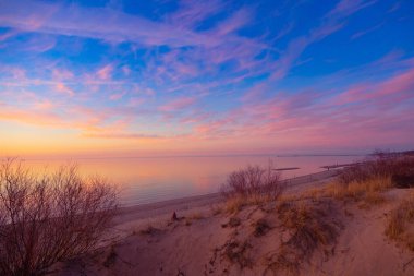 Riga, Letonya 'da bir Baltık Denizi sahilinin güzel bir bahar gün batımı manzarası. Kuzey Avrupa 'nın renkli akşam manzarası.