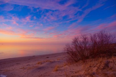 Riga, Letonya 'da bir Baltık Denizi sahilinin güzel bir bahar gün batımı manzarası. Kuzey Avrupa 'nın renkli akşam manzarası.