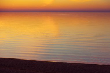 Baltık Denizi 'nde gün batımının güzel minimalist manzarası. Kuzey Avrupa 'nın renkli plaj manzarası.