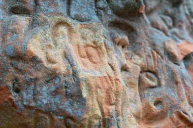 Üzerinde oyma işaretler olan güzel bir kumtaşı uçurum duvarı. Letonya 'daki Gauja Ulusal Parkı' nın bahar manzarası.