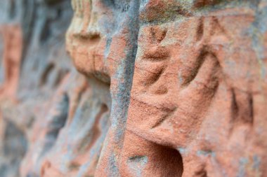 Üzerinde oyma işaretler olan güzel bir kumtaşı uçurum duvarı. Letonya 'daki Gauja Ulusal Parkı' nın bahar manzarası.