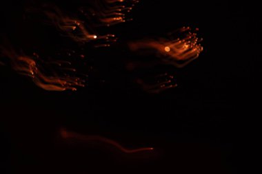 Karanlık gökyüzünde yılbaşı havai fişeklerinin sanatsal bir resmi. Uzun pozlama, bokeh, çekimser. Kutlamanın renkli ve soyut bir resmi.