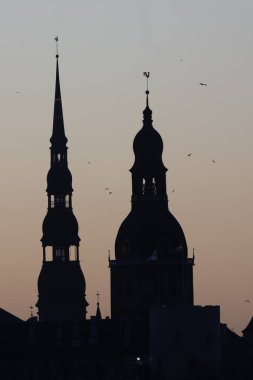 A beautiful Riga cityscape during colorful sunrise. Buildings against colorful sky. Norther Europe morning with warm sky.