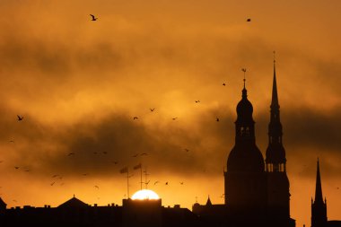A beautiful Riga cityscape during colorful sunrise. Buildings against colorful sky. Norther Europe morning with warm sky.