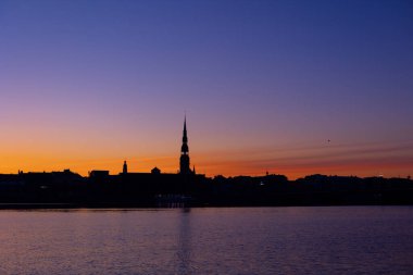 A beautiful Riga cityscape during colorful sunrise. Buildings against colorful sky. Norther Europe morning with warm sky.