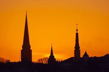 Gün doğumunda Letonya, Riga 'nın güzel bir manzarası. Renkli gökyüzüne karşı kilise kuleleri. Sabahları binalarla dolu bir panorama..