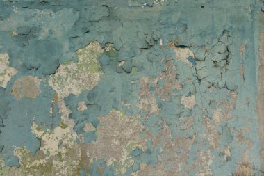 Terk edilmiş bir binanın duvarında eski, soyulmuş bir boya. Çatlak boya dokusu.