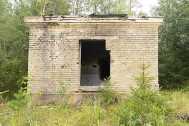 An old, collapsed building in soviet army base in Latvia, Europe. Abandoned white brick building.