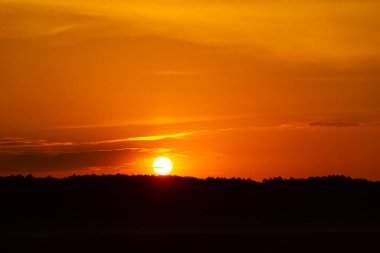 Renkli gündoğumu gökyüzüne sahip güzel bir minimalist manzara. Letonya kırsalının parlak yaz manzarası, Kuzey Avrupa.