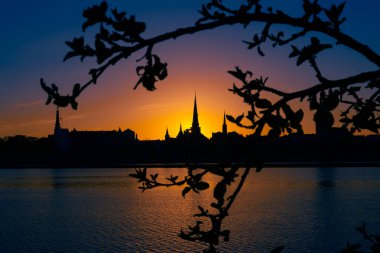 Riga, Letonya 'nın yaz gündoğumunda güzel bir şehir merkezi panoraması. Parlak gökyüzüne karşı siluetler inşa eden renkli bir manzara.