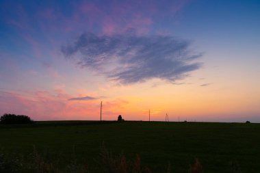 Letonya kırsalında güzel bir yaz gündoğumu. Karanlık arkaplan ile aydınlık sabah gökyüzü.