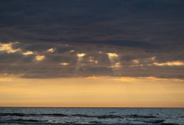 Baltık Denizi üzerinde güzel bir gün doğumu. Ufuk ve renkli gökyüzü. Letonya, Kuzey Avrupa 'daki Baltık plajında doğal yaz manzarası.