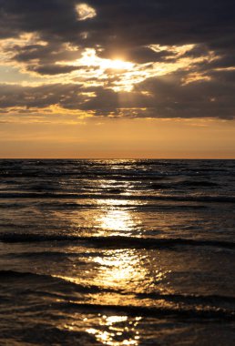 Baltık Denizi üzerinde güzel bir gün doğumu. Ufuk ve renkli gökyüzü. Letonya, Kuzey Avrupa 'daki Baltık plajında doğal yaz manzarası.