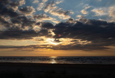 Baltık Denizi üzerinde güzel bir gün doğumu. Ufuk ve renkli gökyüzü. Letonya, Kuzey Avrupa 'daki Baltık plajında doğal yaz manzarası.